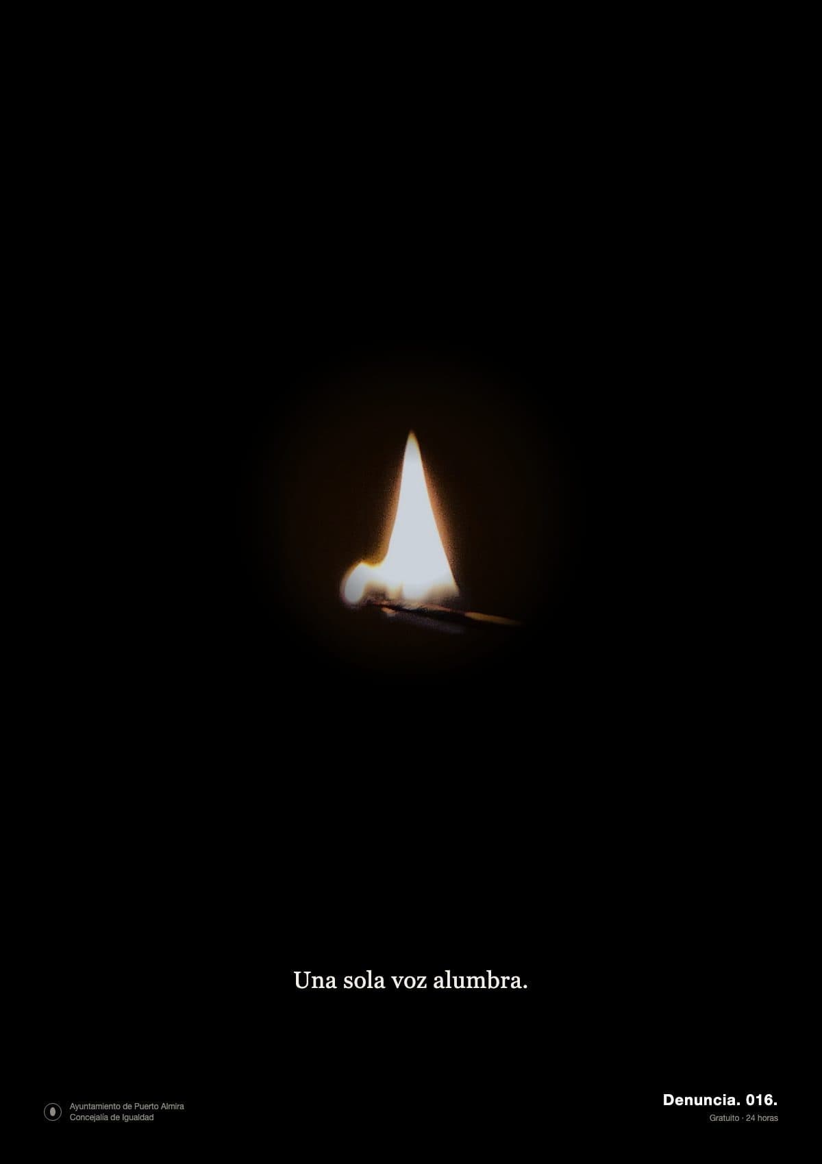 Cartel vertical de fondo negro total. En el centro, diminuta y sola, una cerilla encendida: una llama blanca y anaranjada sobre un palito fino, que ilumina apenas un pequeño círculo de luz cálida a su alrededor; todo lo demás es oscuridad. Abajo, centrado, en letra blanca pequeña: «Una sola voz alumbra.». En la esquina inferior derecha, aún más pequeño: «Denuncia. 016.» y «Gratuito · 24 horas». En la esquina izquierda, en gris, el logo del «Ayuntamiento de Puerto Almira · Concejalía de Igualdad».